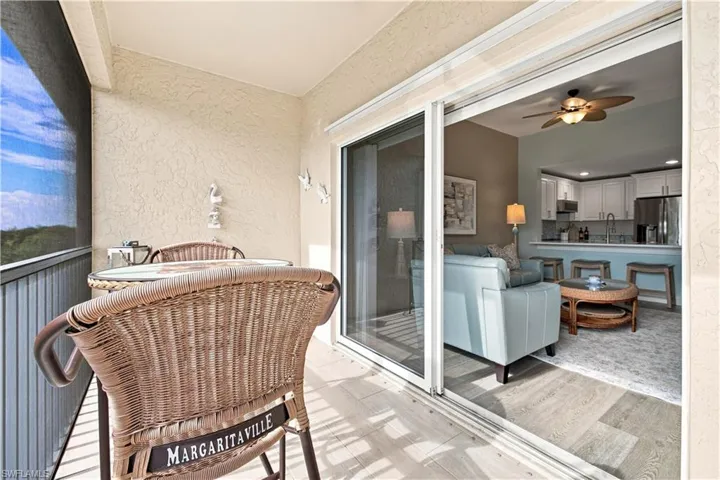 Screened balcony featuring textured wall finish and wood-look flooring