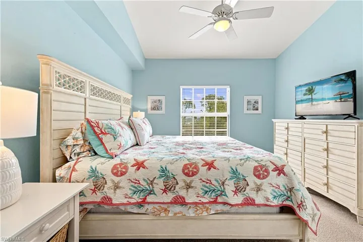 Recessed ceiling with integrated lighting, window with blinds, ceiling fan with light fixture, light-toned wood-finish furniture, and wall-mounted television