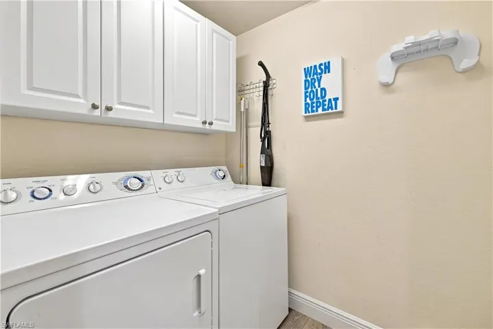 White cabinetry with satin nickel hardware and built-in laundry appliances