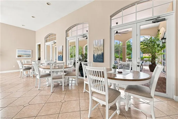 Spacious interior featuring neutral tone walls, recessed lighting, tile flooring, and multiple arched French doors with transoms
