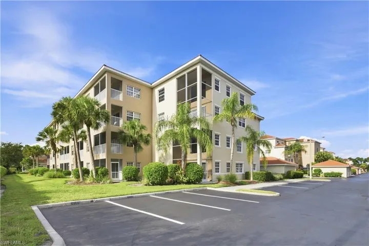 Multi-story building featuring stucco exterior, screened balconies, and white-framed windows