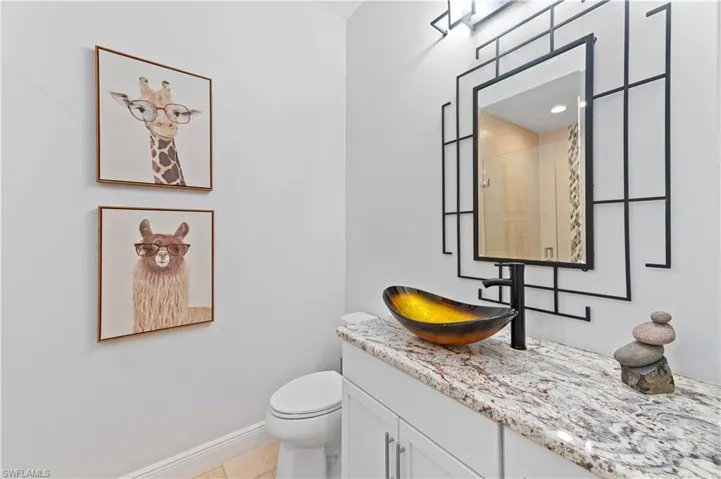 Bathroom featuring walk in shower, vanity, toilet, and tile patterned floors
