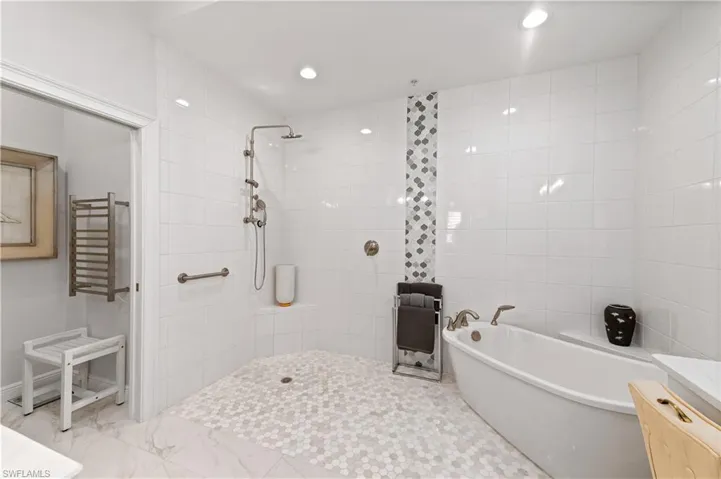 Bathroom featuring vanity and separate shower and tub