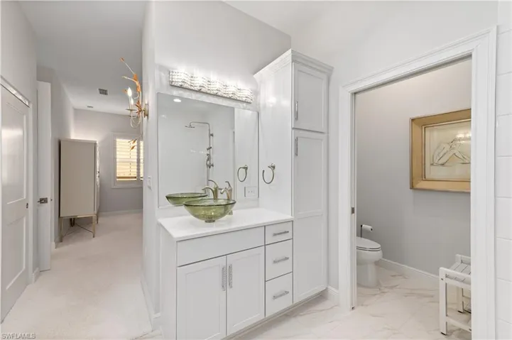 Bathroom featuring walk in shower, vanity, and toilet