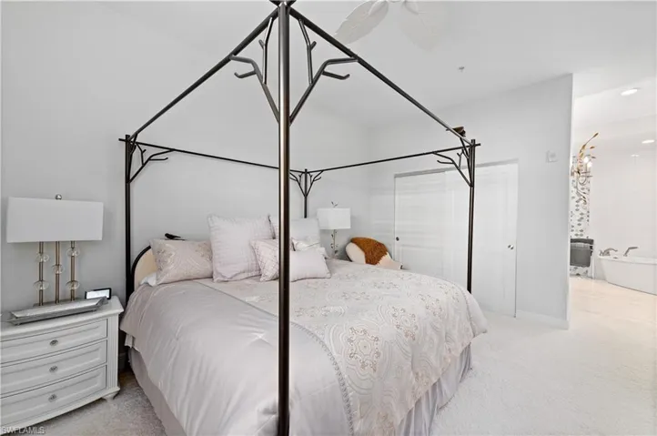 Carpeted bedroom with ceiling fan and ensuite bathroom