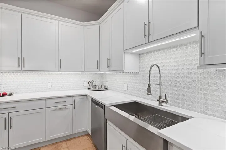 Kitchen with backsplash, sink, and stainless steel dishwasher