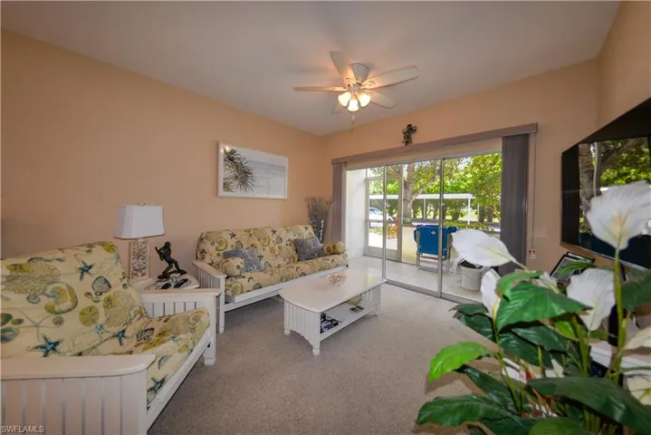 Living room with carpet flooring and ceiling fan