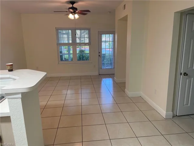 Unfurnished dining area with light tile patterned floors and a ceiling fan