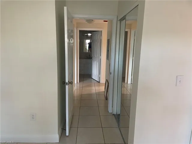 Hallway featuring baseboards and light tile patterned flooring