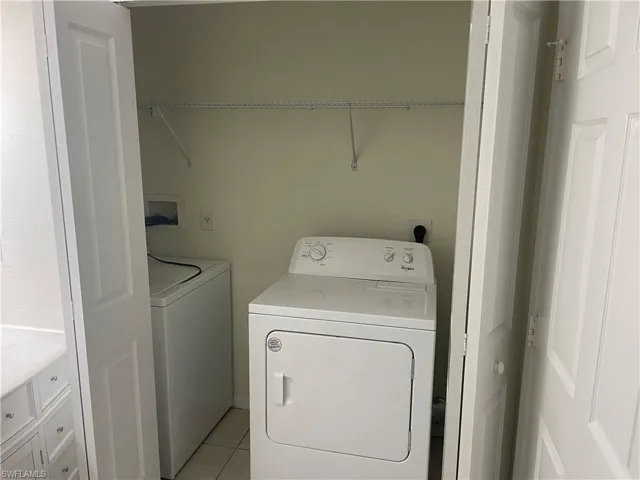 Laundry room featuring separate washer and dryer and light tile patterned floors