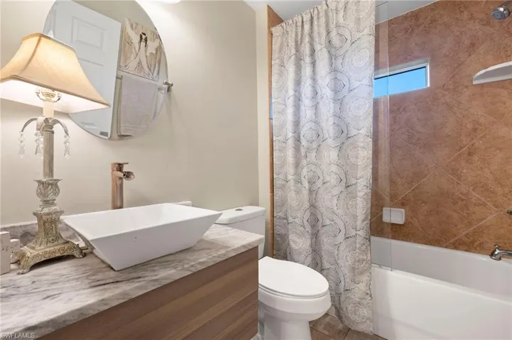 Full bathroom with vanity, toilet, and shower / tub combo with curtain