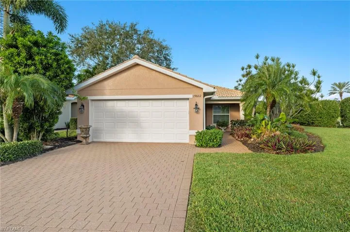Ranch-style home featuring a garage and a front lawn
