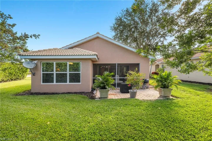 Back of house featuring a sunroom, a patio area, and a yard