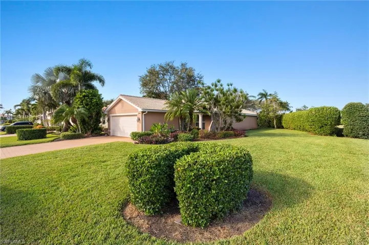 Single story home with a garage and a front lawn