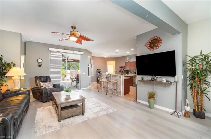 Living room with ceiling fan and light hardwood / wood-style flooring
