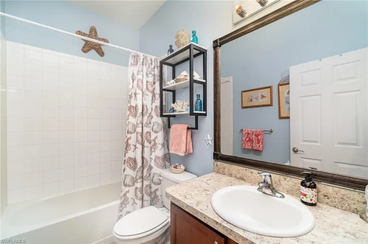 Full bathroom with oversized vanity, toilet, and shower / tub combo with curtain