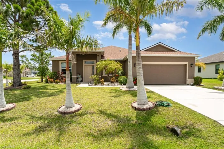View of front of house with a garage and a front yard