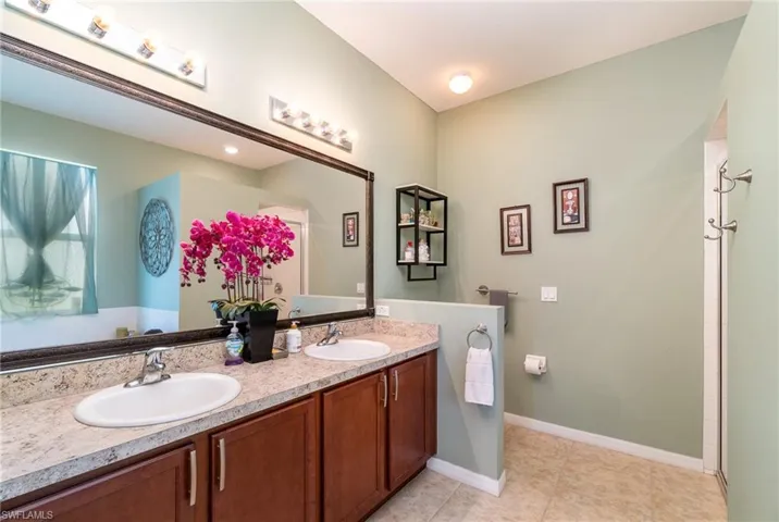 Bathroom featuring tile flooring, large vanity, and dual sinks