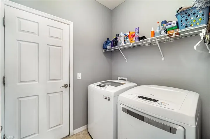 Washroom featuring washer and dryer, light tile flooring, and hookup for a washing machine