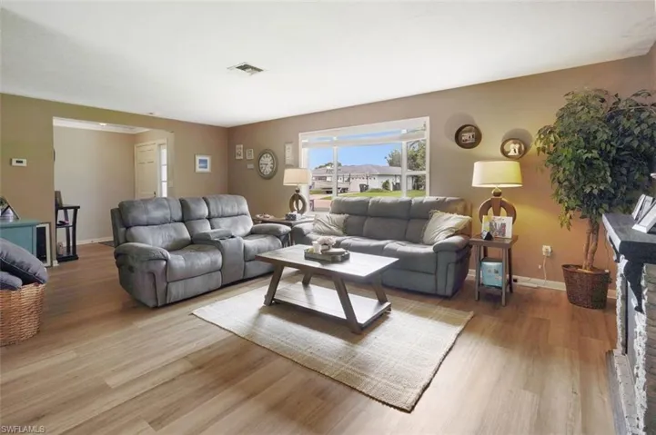 Living room featuring light hardwood / wood-style flooring and a stone fireplace
