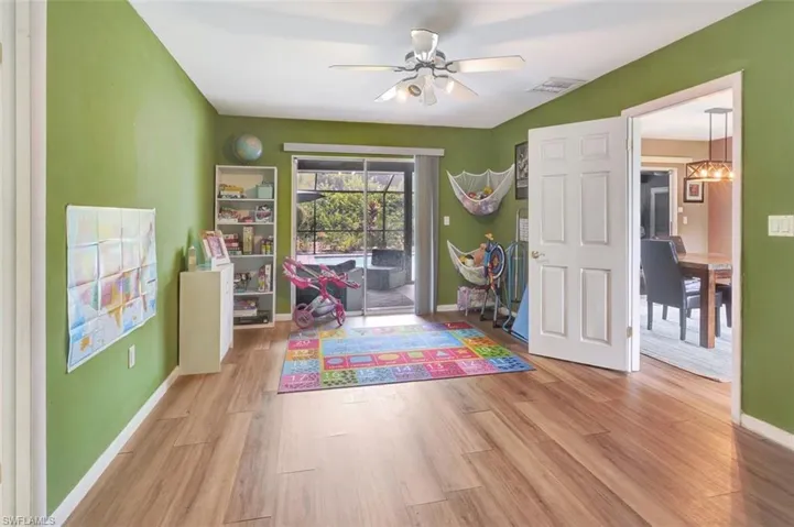 Rec room featuring light wood-type flooring and ceiling fan with notable chandelier