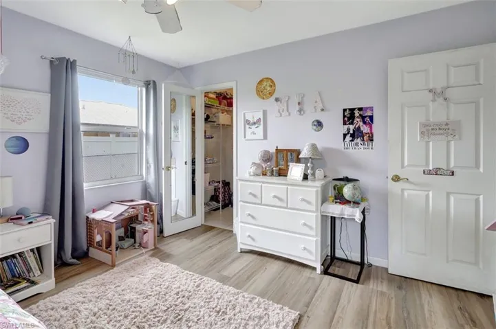 Bedroom featuring ceiling fan, light wood-type flooring, a closet, and a spacious closet