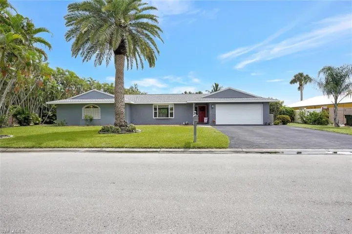 Ranch-style house with a garage and a front lawn