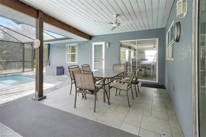Sunroom / solarium featuring beamed ceiling and ceiling fan