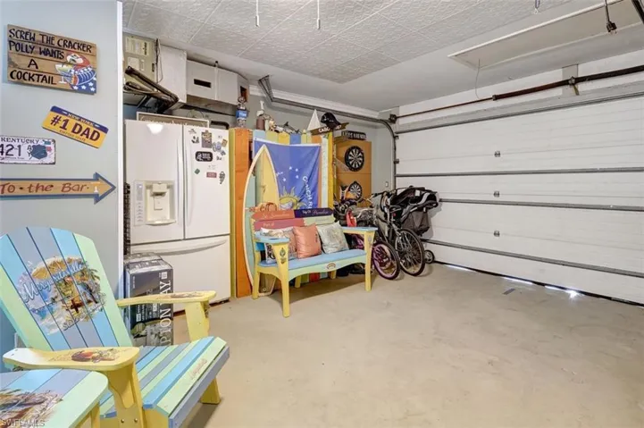 Garage featuring white refrigerator with ice dispenser