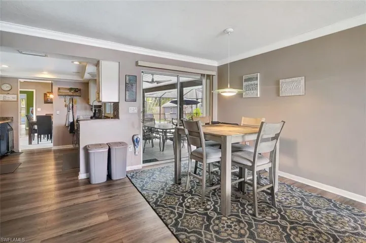 Dining space with dark wood-type flooring and ornamental molding