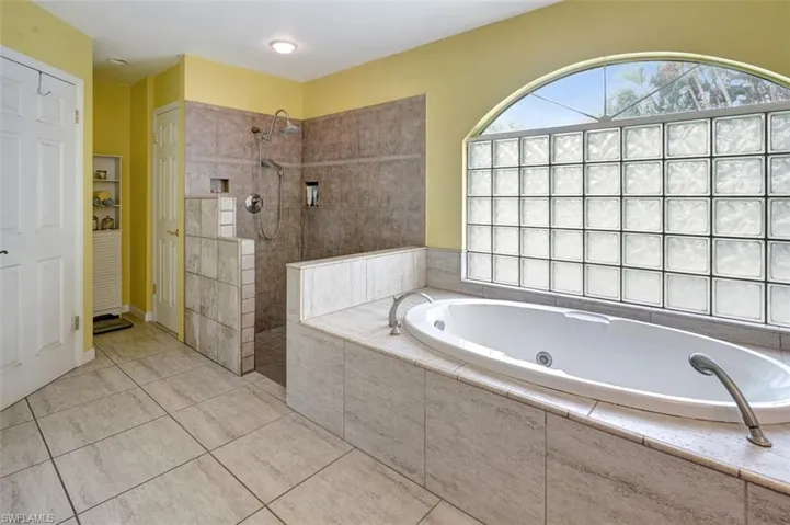Bathroom with separate shower and tub and tile patterned floors