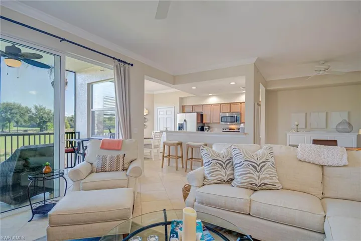 Living room with a ceiling fan, recessed lighting, ornamental molding, and light tile patterned floors