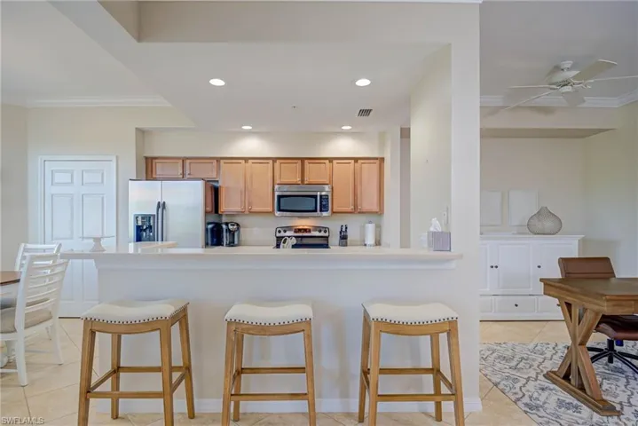 Kitchen with crown molding, a breakfast bar, and stainless steel appliances