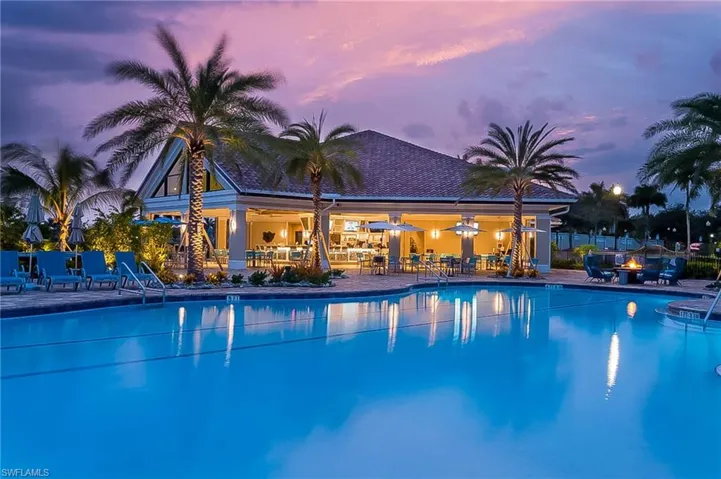 Pool at dusk featuring a community pool, a patio area, and an outdoor fire pit