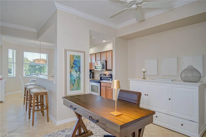 Office area featuring light tile patterned floors, baseboards, and ornamental molding