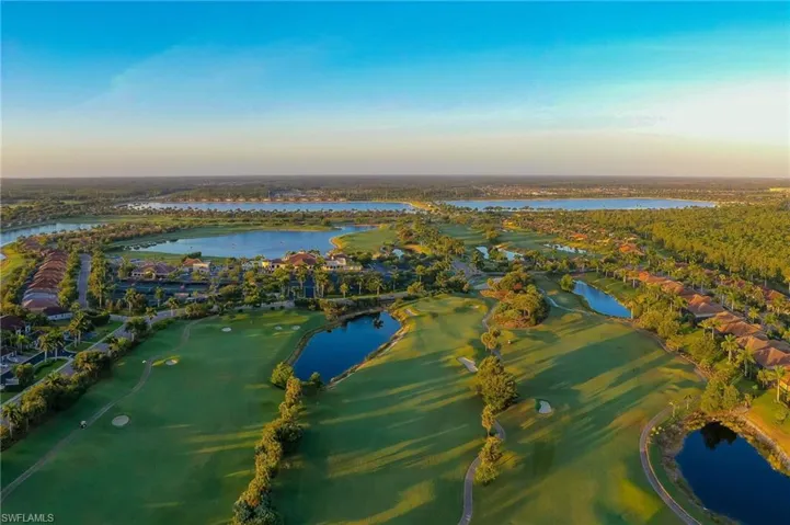 Aerial view at dusk featuring a water view, a residential view, and golf course view