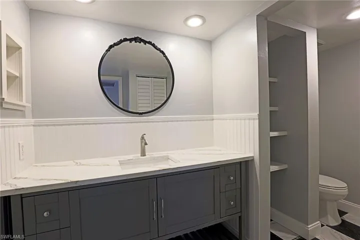 Full bathroom featuring vanity, built in shelves, and recessed lighting