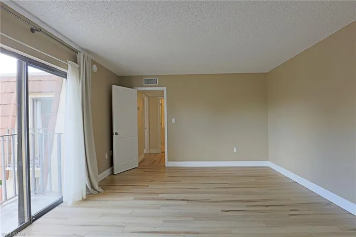 Empty room with light wood-style flooring and a textured ceiling