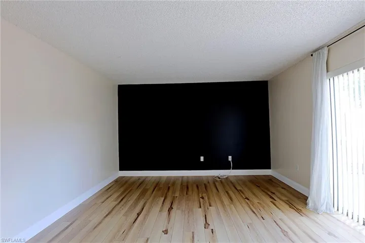 Unfurnished room featuring light wood-style floors and a textured ceiling
