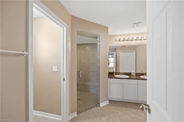 Bathroom featuring vanity, an enclosed shower, and tile patterned floors
