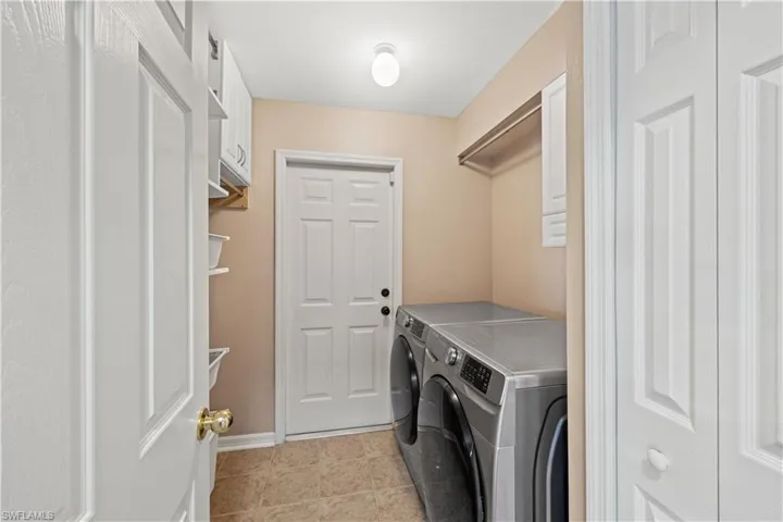 Laundry room with light tile patterned flooring and separate washer and dryer