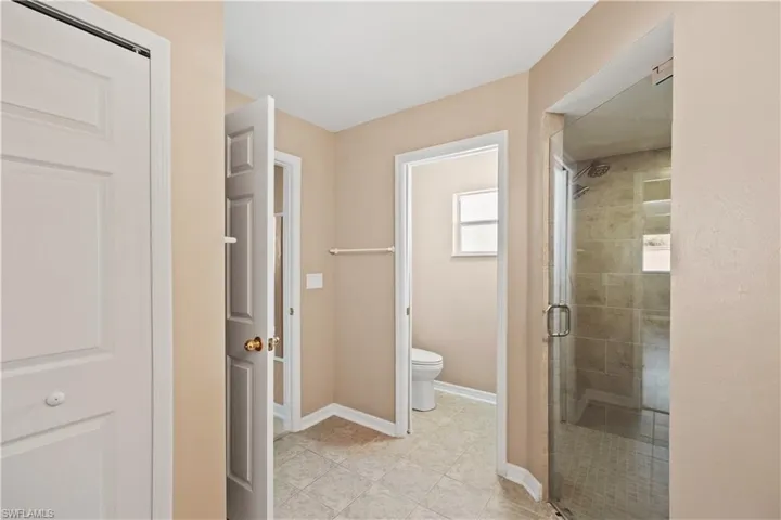Bathroom with tile patterned floors, toilet, and walk in shower