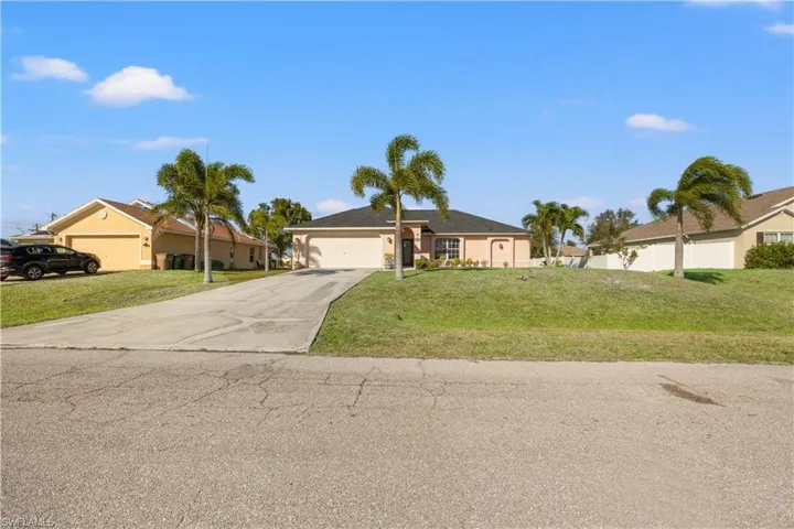 Ranch-style house featuring a front lawn and a garage