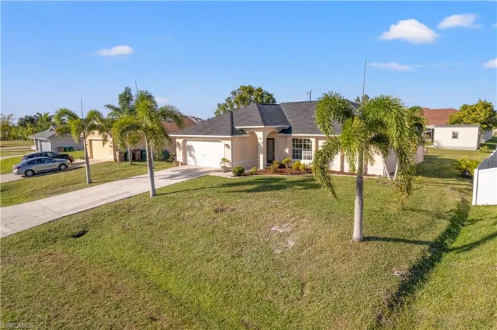 View of front of home with a front lawn and a garage