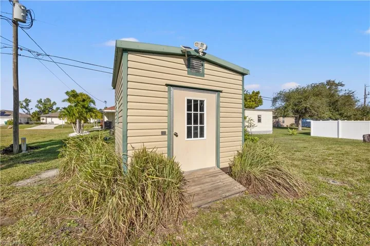 View of storage shed with a yard