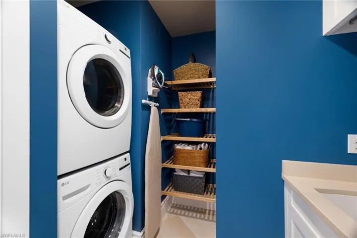 laundry room with stackable appliances and build in storage