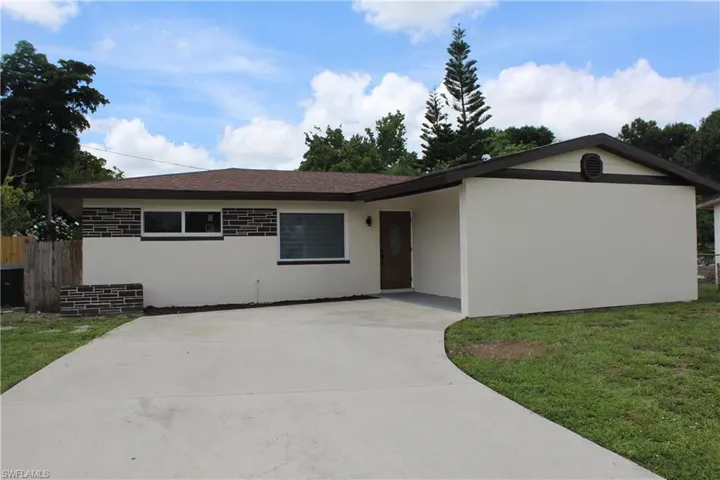 Ranch-style home featuring stucco siding, driveway, and a shingled roof