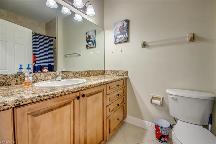 Bathroom featuring light tile patterned flooring, vanity, and curtained shower