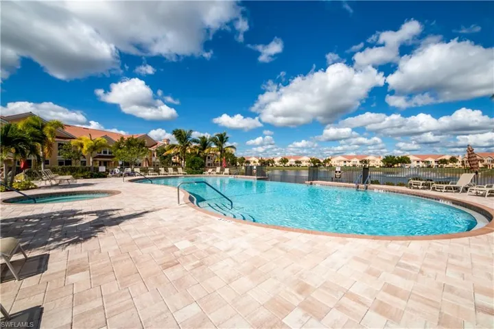 Community pool featuring a patio, a community hot tub, and a residential view
