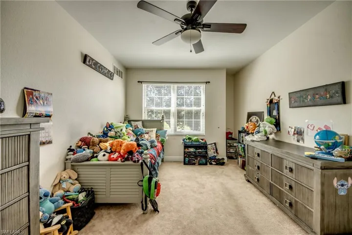 Bedroom with light colored carpet and ceiling fan